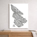 Black and white map of Salt Spring Island on a white wall above a wooden shelf.
