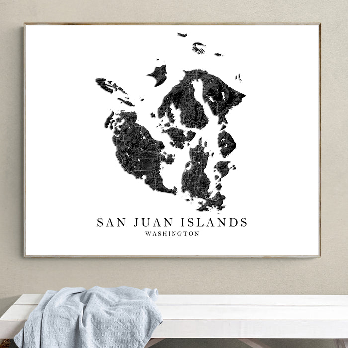 Framed map of San Juan Islands, Washington on a wall above a white bench.