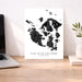 Map of San Juan Islands, Washington on a white background next to a laptop on a wooden desk.
