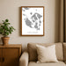 Framed map of San Juan Islands on a wall above a beige sofa with a plant beside it.