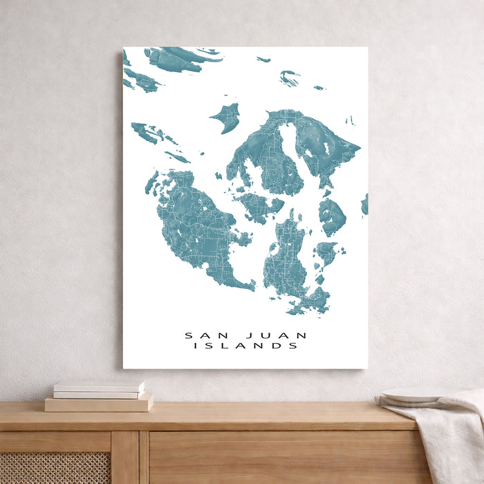 Map of San Juan Islands on a white wall above a wooden surface