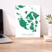 Map of San Juan Islands on a white background, displayed on a wooden desk with a laptop and plant.