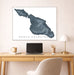 Framed map of Santa Catalina on a wall above a desk with a laptop and lamp.