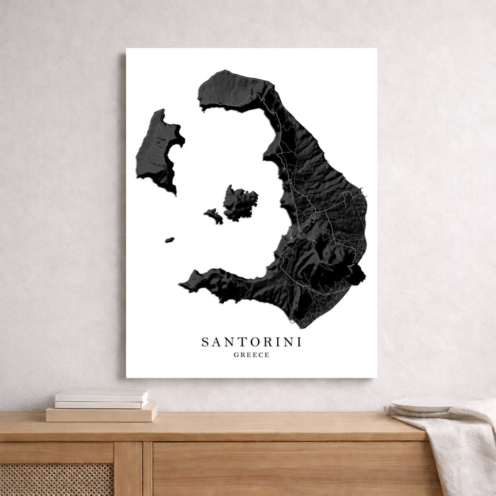 Map of Santorini, Greece on a white background, displayed on a wall above a wooden shelf.