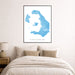 Framed map of Santorini on a wall above a bed with beige bedding.
