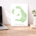 Map of Santorini on a desk with a laptop and plant