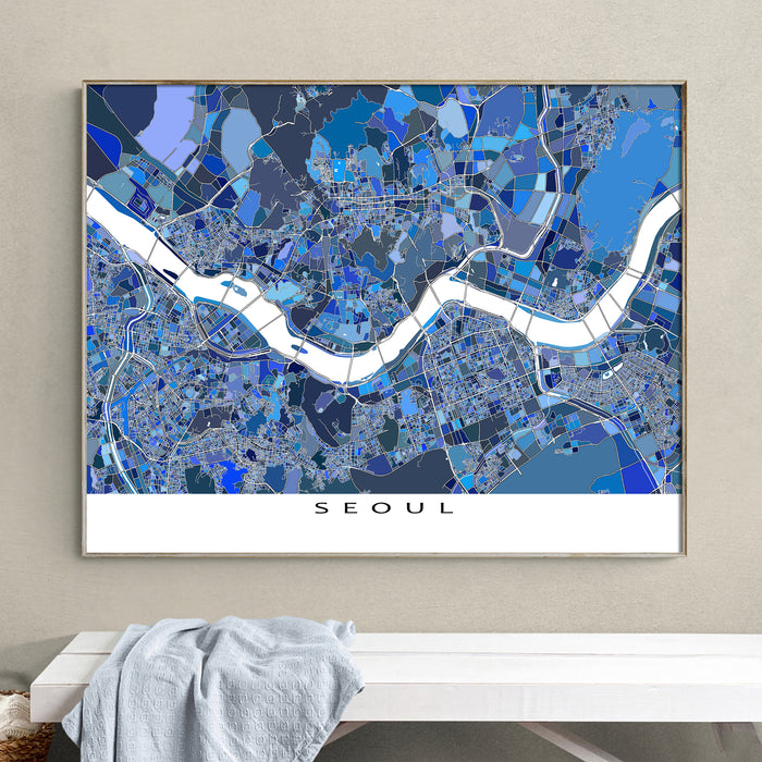 Framed map of Seoul on a wall above a white bench.