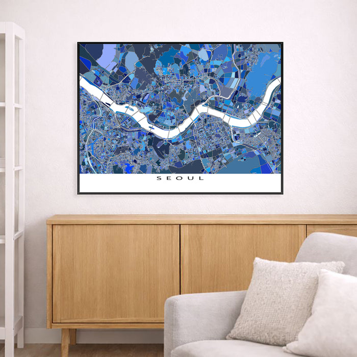 Framed map of Seoul on a wall above a wooden cabinet and sofa.