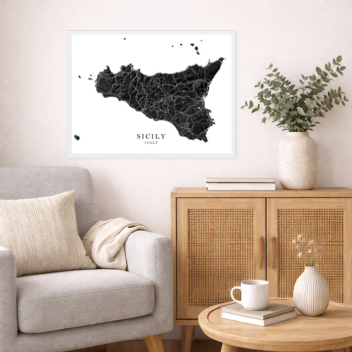 Framed map of Sicily on a wall above a sofa in a living room.