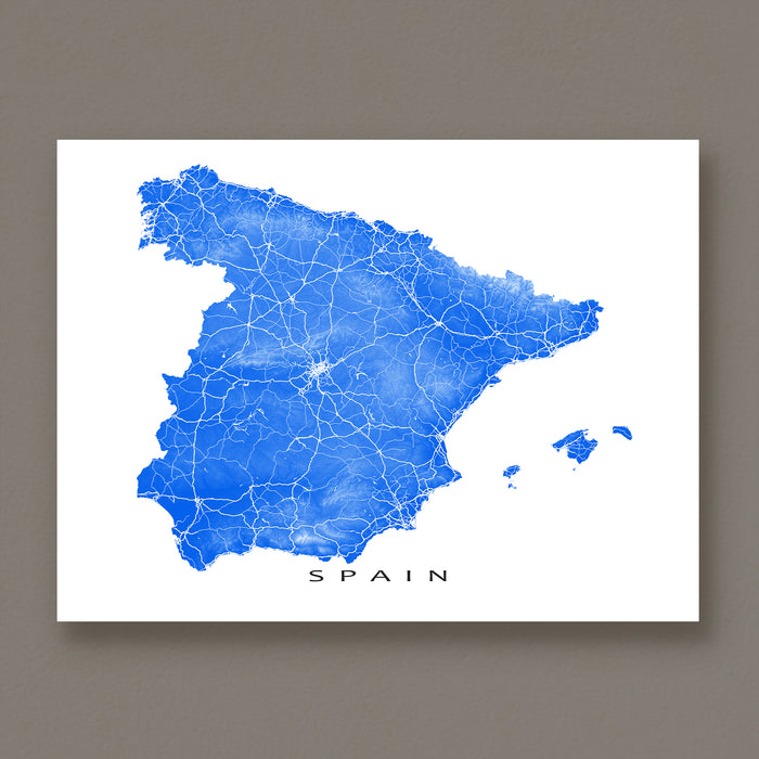 Map of Spain with blue roads on a white background, displayed against a brown wall.