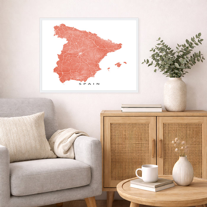Living room with a map of Spain on the wall, a gray sofa, wooden cabinet, and decorative items.