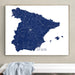 Framed map of Spain on a wall above a white surface.