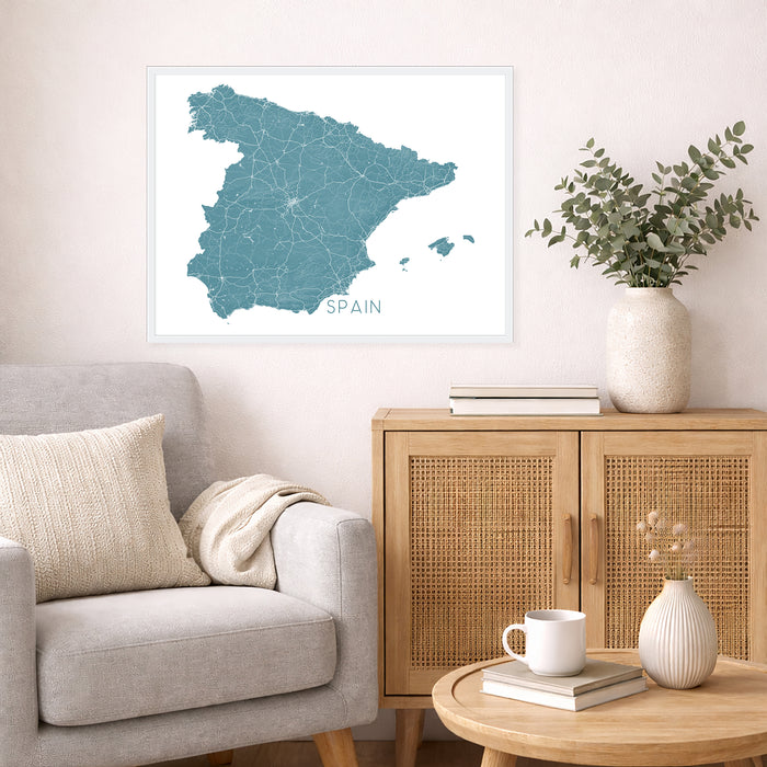 Living room with a map of Spain on the wall, a vase with plants, and a wooden cabinet.
