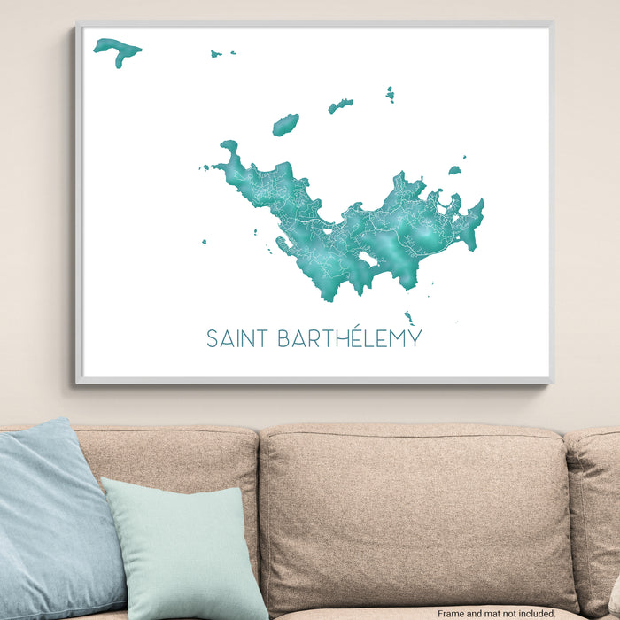 Framed map of Saint Barthélemy on a wall above a beige sofa with light blue pillows.