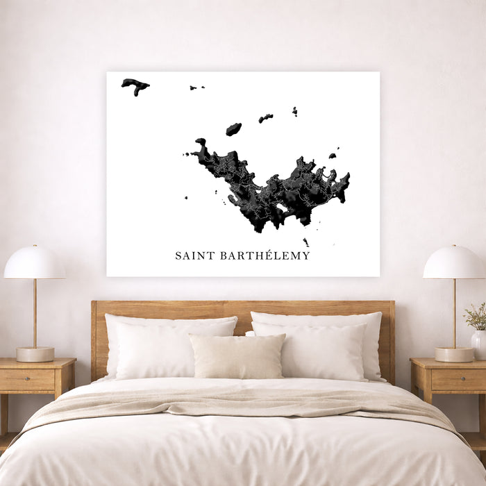 Map of Saint Barthélemy on a wall above a bed in a bedroom.