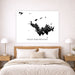 Map of Saint Barthélemy on a wall above a bed in a bedroom.