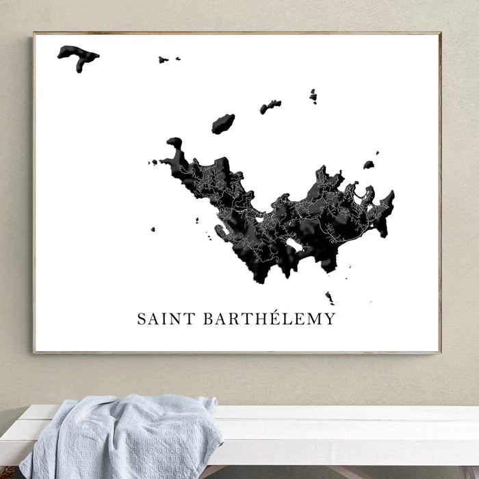 Framed map of Saint Barthélemy on a wall above a white bench.