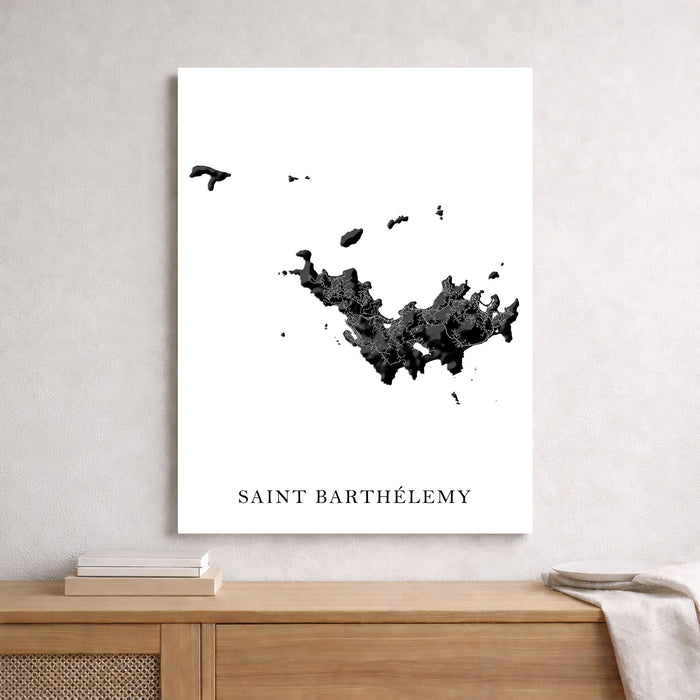 Map of Saint Barthélemy on a white wall above a wooden shelf.