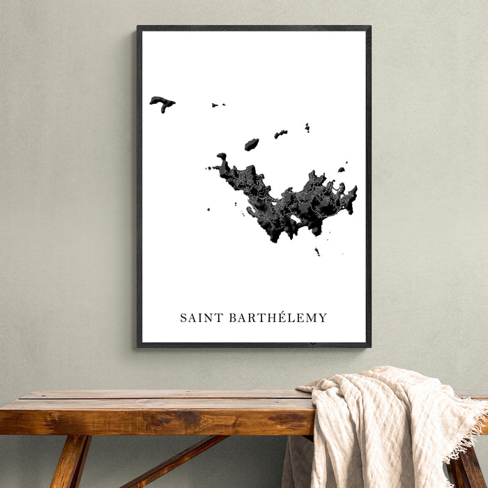 Framed map of Saint Barthélemy on a wall above a wooden bench.