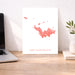 Map of Saint Barthélemy on a white background displayed on a desk with a laptop and plant.