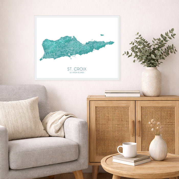 Living room with a map of St. Croix on the wall, a couch, and a side table with a plant and books.