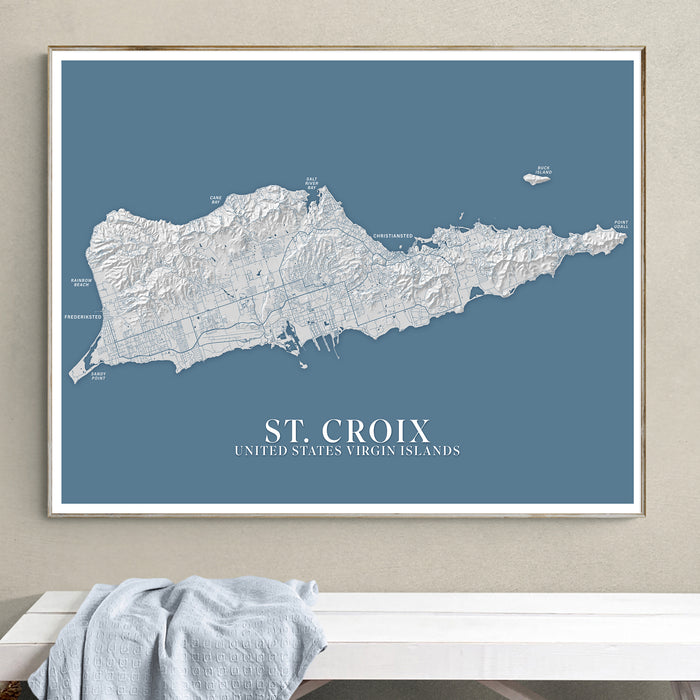 Framed map of St. Croix, United States Virgin Islands on a blue background, hanging on a wall.