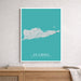 Framed map of St. Croix on a teal background hanging on a wall above a wooden surface.