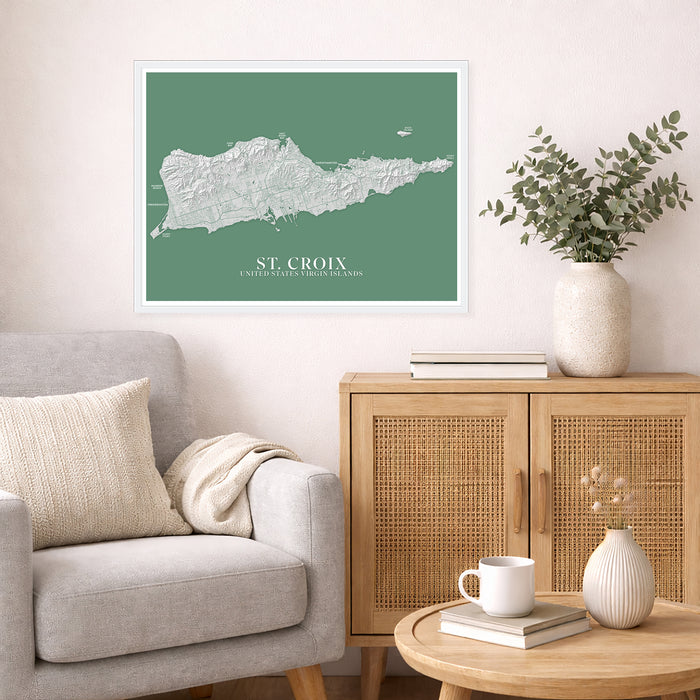 Living room with a map of St. Croix on the wall, a couch, and a side table with a plant and books.