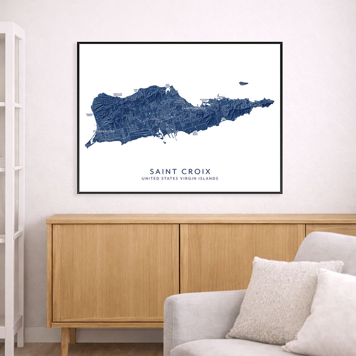Framed map of Saint Croix above a wooden cabinet in a living room.