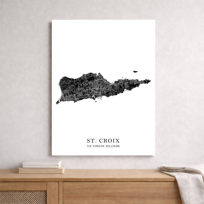 Map of St. Croix, US Virgin Islands on a white wall above a wooden shelf.