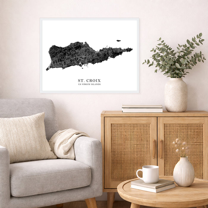 Framed map of St. Croix on a wall in a living room with a couch, cabinet, and table.