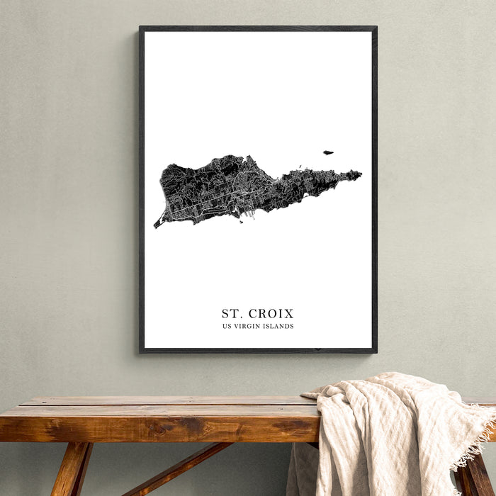 Framed map of St. Croix, US Virgin Islands on a wall above a wooden bench.