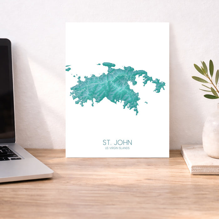 Map of St. John, US Virgin Islands on a desk with a laptop and plant.