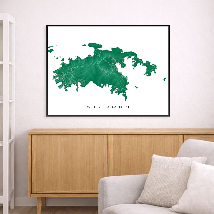 Framed map of St. John on a wall above a wooden cabinet and sofa.