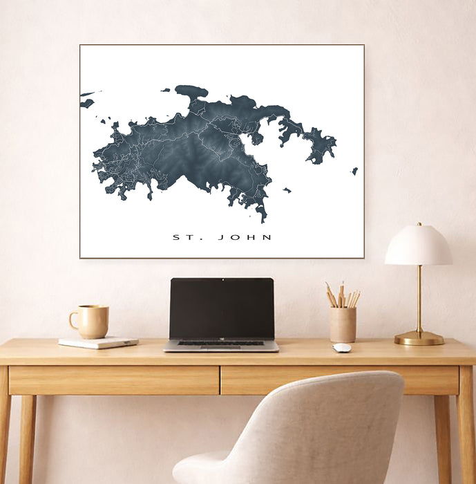 Map of St. John on a wall above a desk with a laptop and lamp.