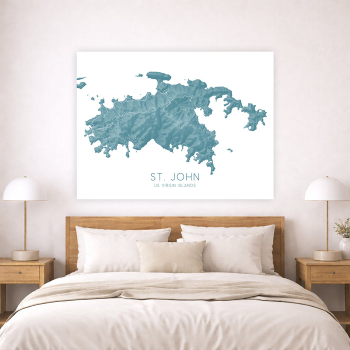 Framed map of St. John, US Virgin Islands on a wall above a bed.