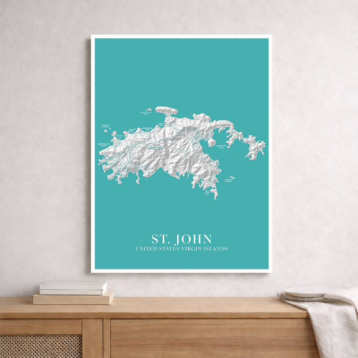 Topographic map of St. John, United States Virgin Islands on a teal background, framed and leaning against a wall.