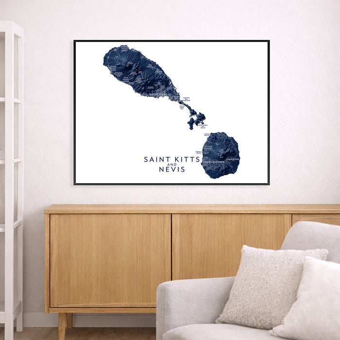 Map of Saint Kitts and Nevis framed on a wall above a wooden cabinet and sofa.