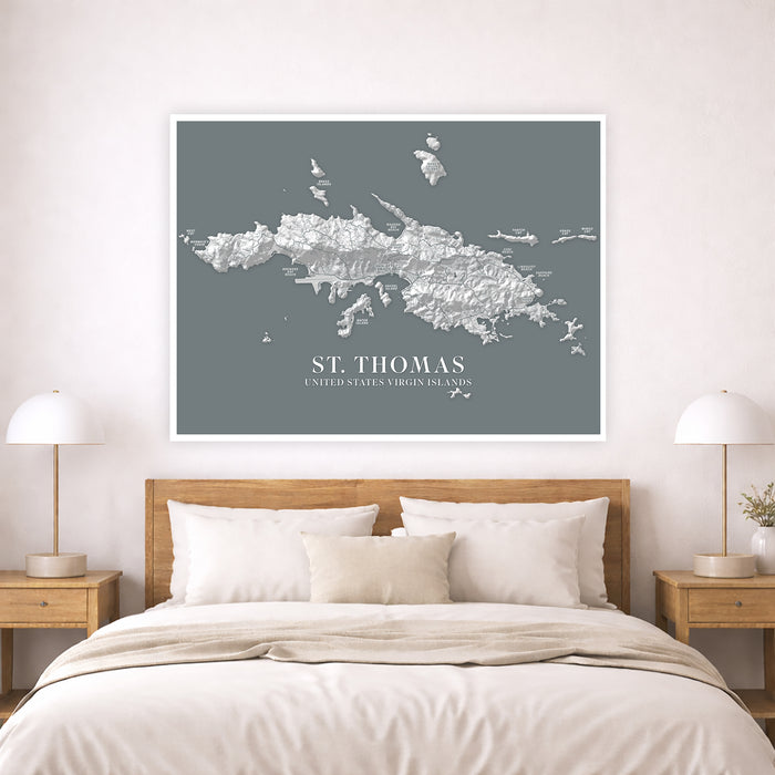 Framed map of St. Thomas above a bed in a bedroom setting