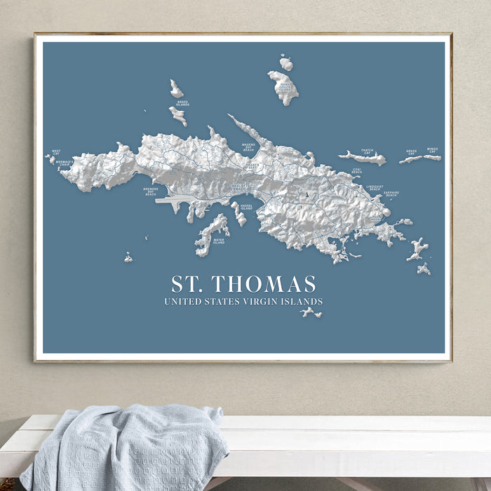 Framed map of St. Thomas on a wall above a white surface.