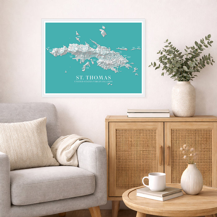 Framed map of St. Thomas on a wall above a sofa and side table with decor items.