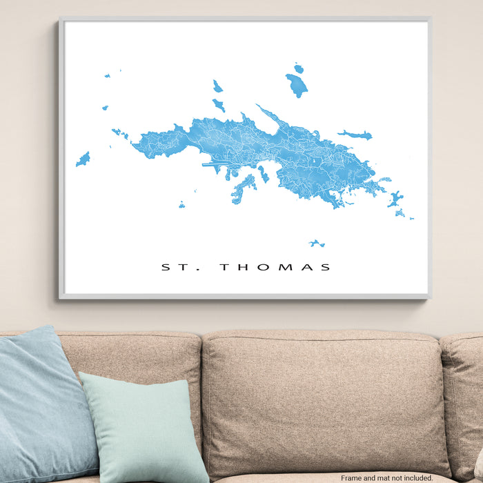 Framed map of St. Thomas on a wall above a beige sofa with light blue pillows.