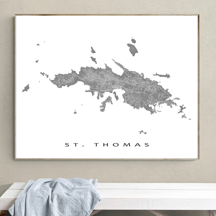 Framed map of St. Thomas on a wall above a white bench.