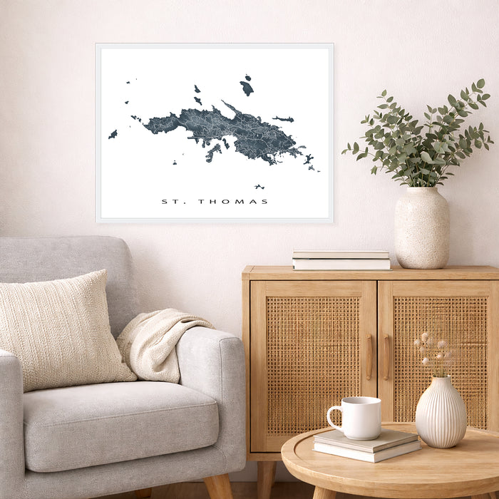 Living room with a map of St. Thomas on the wall, a couch, and a wooden cabinet.
