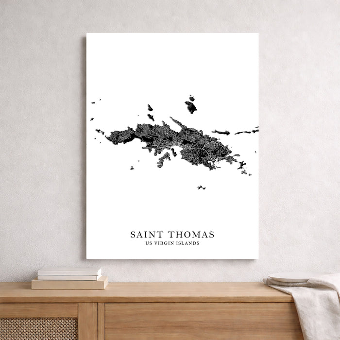 Map of Saint Thomas, US Virgin Islands on a white wall above a wooden shelf.