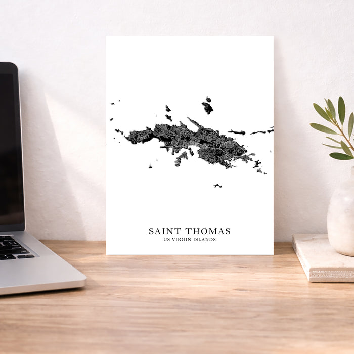 Map of Saint Thomas, US Virgin Islands on a desk with a laptop and plant.