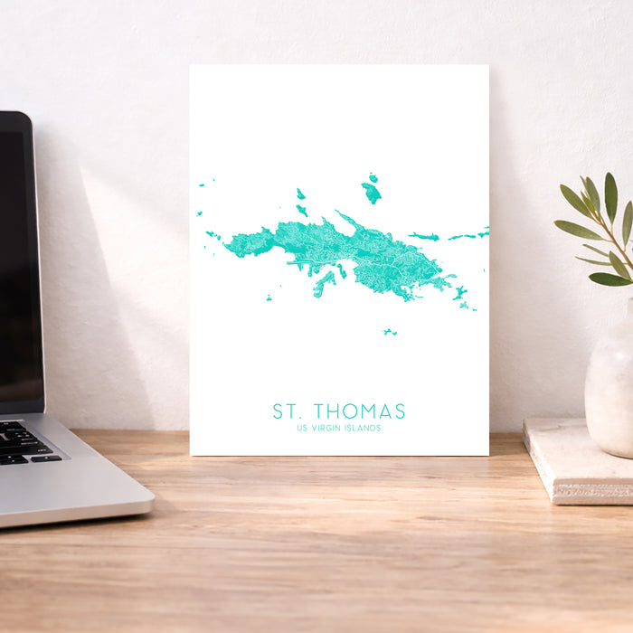 Map of St. Thomas on a desk with a laptop and plant