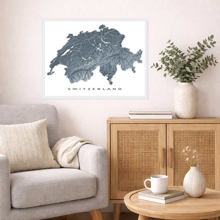 Living room with a map of Switzerland on the wall, a couch, and a wooden cabinet.