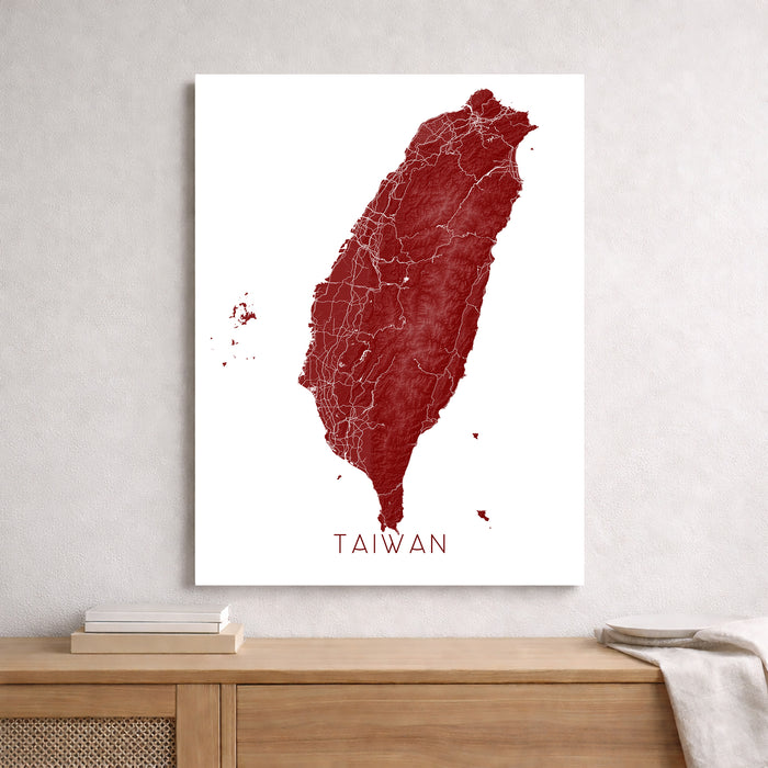 Map of Taiwan in red on a white background, displayed on a wall above a wooden shelf.