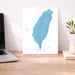 Map of Taiwan on a desk with a laptop and plant